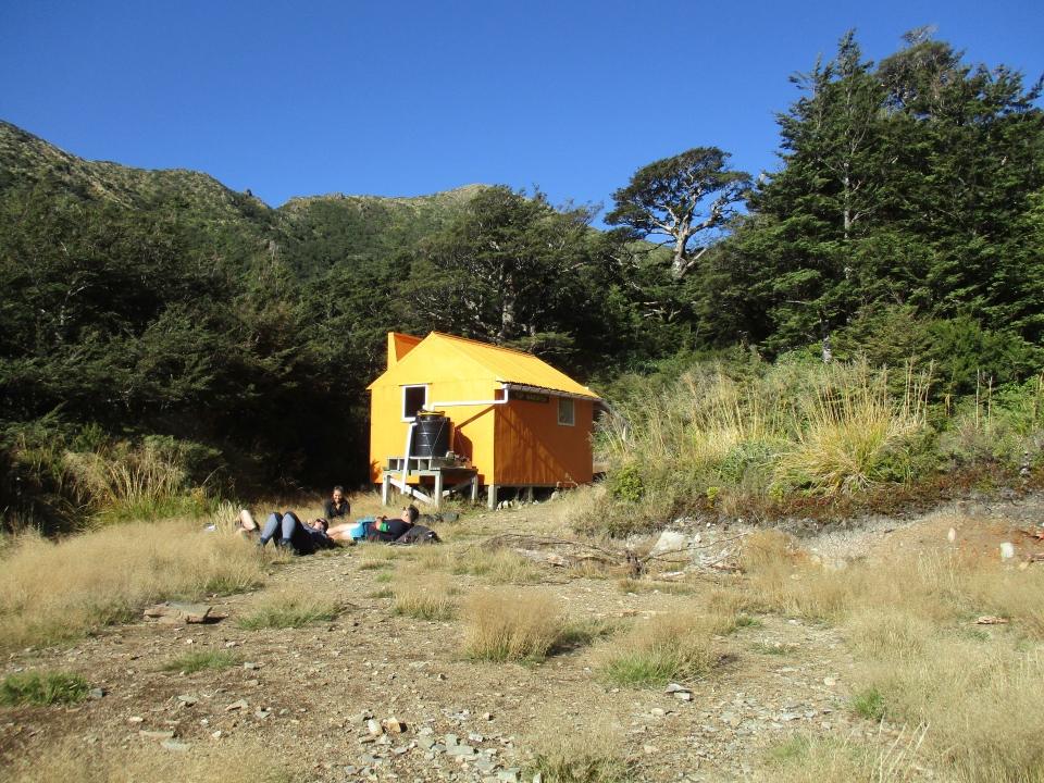 Trampers lying in the sun outside Top Maropea Hut