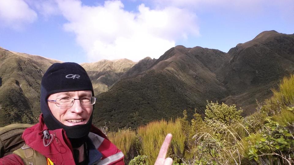 Tramper pointing at a spur he climbed