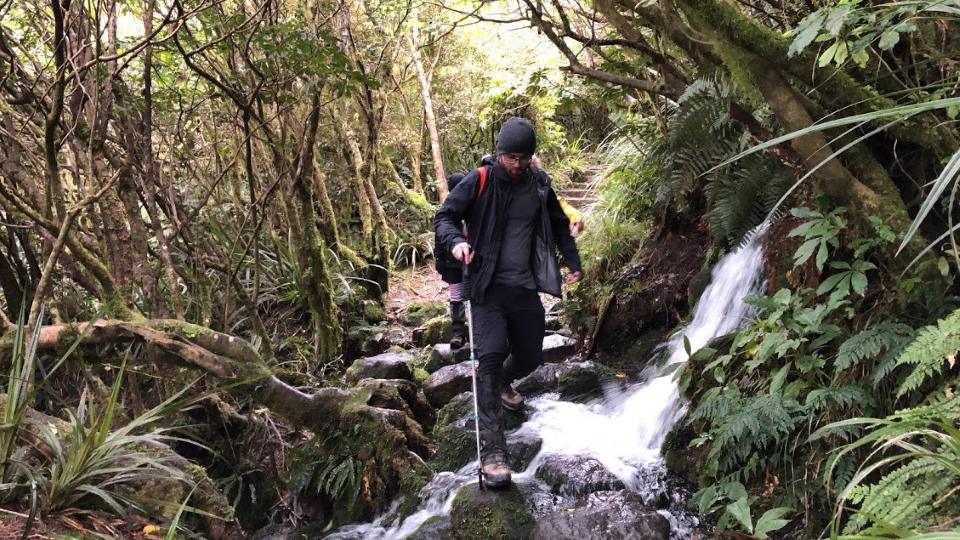 Tramper walking over a stream