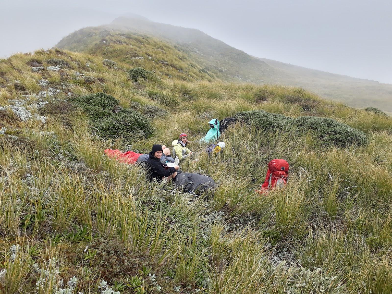 Jamie, Anna, and Loretha enjoy a welcome late lunch - tucked in out of the wind just below the ridge