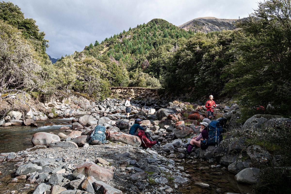 Trampers sitting in a rocky stream