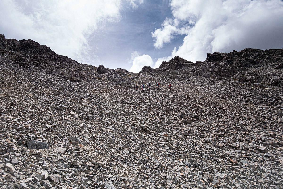 Five trampers descending a scree slope