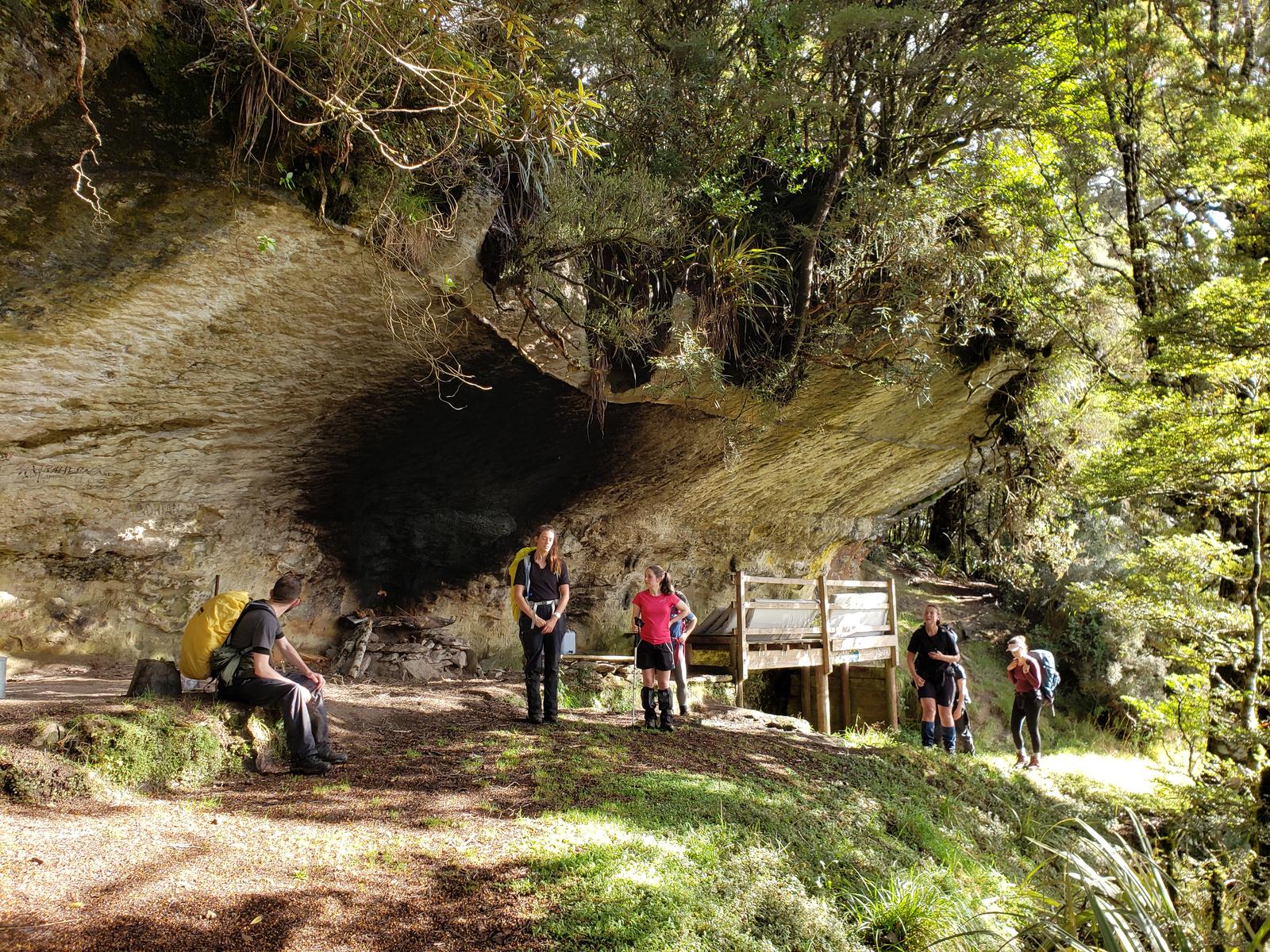 Trampers at a large rock shelter