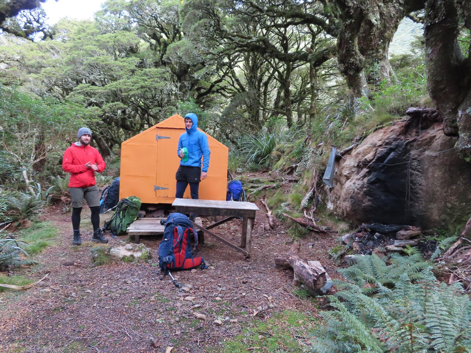 Two trampers by an orange bivvy