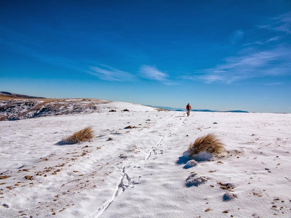 Mountain biking through the snow on the Hawkdun Range, Otago