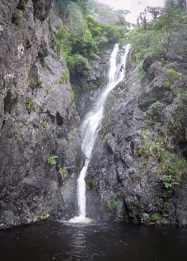 Megan with the gear bag descents the last 40 m waterfall Eager Beaver Canyon