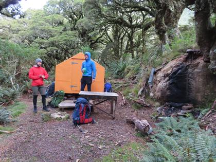 Two trampers by an orange bivvy