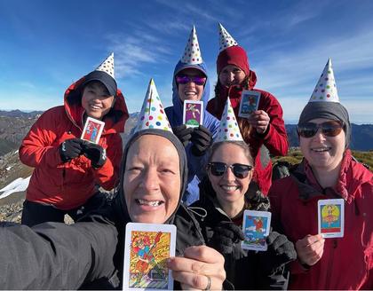 Trampers wearing unicorn party hats on the summit of Kākāpō Peak