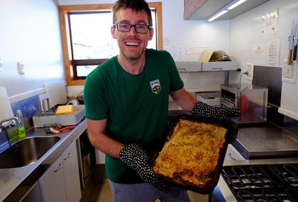 Nick holding a dish of lasagne at WTMC Ski Lodge
