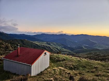 Hikurangi Hut basking in the morning sun, overlooking the Raukūmara Ranges (Credit: Sara)