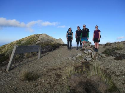 Trampers on a ridge near a sign in the Ruahine Ranges