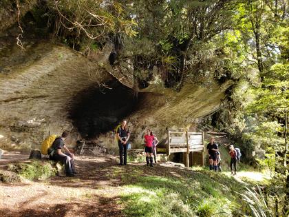 Trampers at a large rock shelter