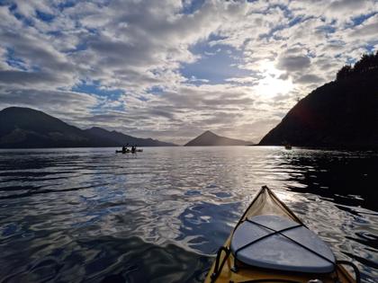 View over the prow of a kayak at sea, evening