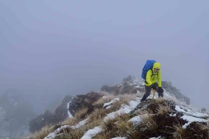 Tramper in low visibility on top of a ridge