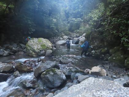 Trampers wading up a stream