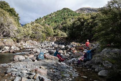 Trampers sitting in a rocky stream