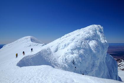 Three people waking up Mt Ruapehu's crater rim