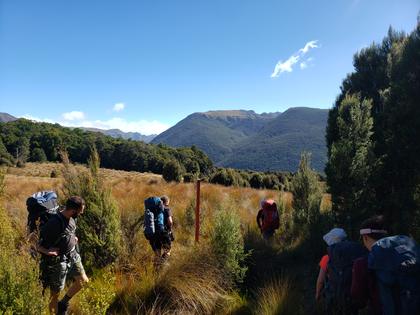 Trampers crossing a grassy field