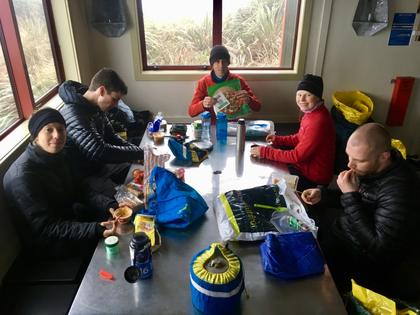 Trampers eating lunch in a hut