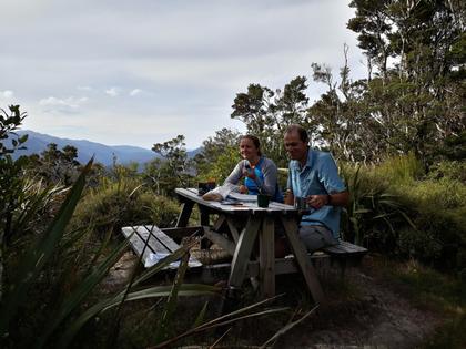 Two people sitting at a table outside