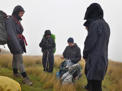 Nutter doing a crossword surrounded by trampers and fog