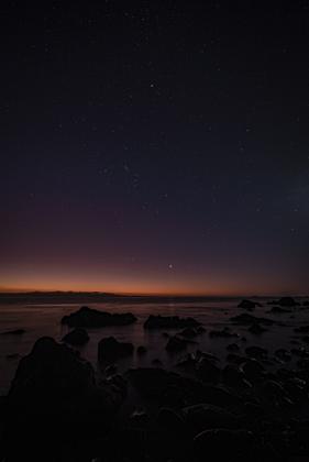 The planet Venus and the constellation of Orion above the glassy sea