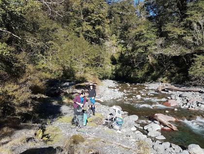 Emptying boots of water after a short wander up the river. Photo credit: Patrick.