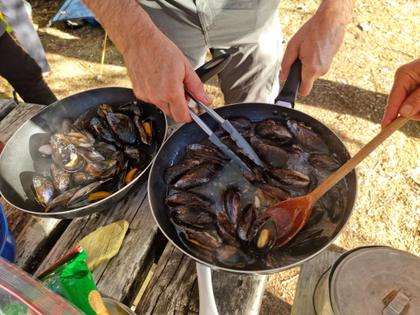 Two pans of mussels cooking