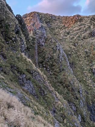 The steel ladder in the morning sun on the intimidating slopes of Tuiti