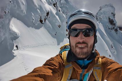 Gareth takes a selfie at our anchor at the base of First Pinnacle, with Henry waiting on the saddle below, and our tracks tracing back around Middle Pinnacle (credit Gareth)