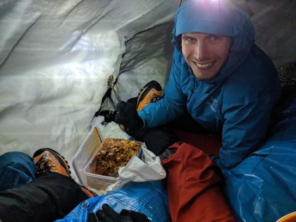 Lukas eating dinner in a snow cave