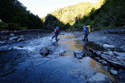 Two people crossing a river
