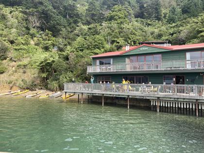 A lodge with a balcony over the water. Bush backdrop